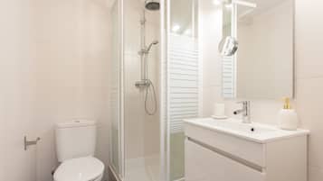 Studio (2.º Esq) | Badkamer | Een douche, een haardroger, handdoeken, toiletpapier