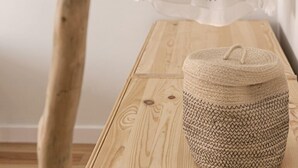 A wooden hanger with a scarf and a woven basket on a wooden table. - Bairro Studio Apartment - by LU Holidays (Lisbon)