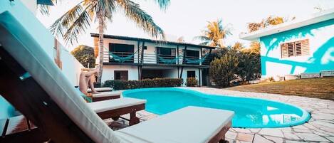 Alberca al aire libre y camastros