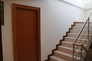 Stairs lead to a door marked 305 in a building's interior.
