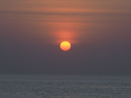 A sunset over the ocean with a clear sky.