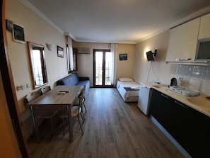 A compact living space with a dining area, kitchenette, and a small bed. - Dasis Hotel & Suites (Bodrum)