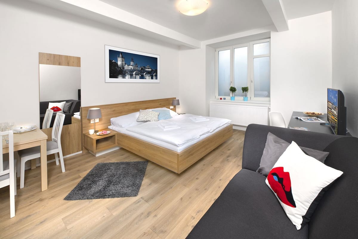 Een moderne hotelkamer met een bed, bureau en zithoek.