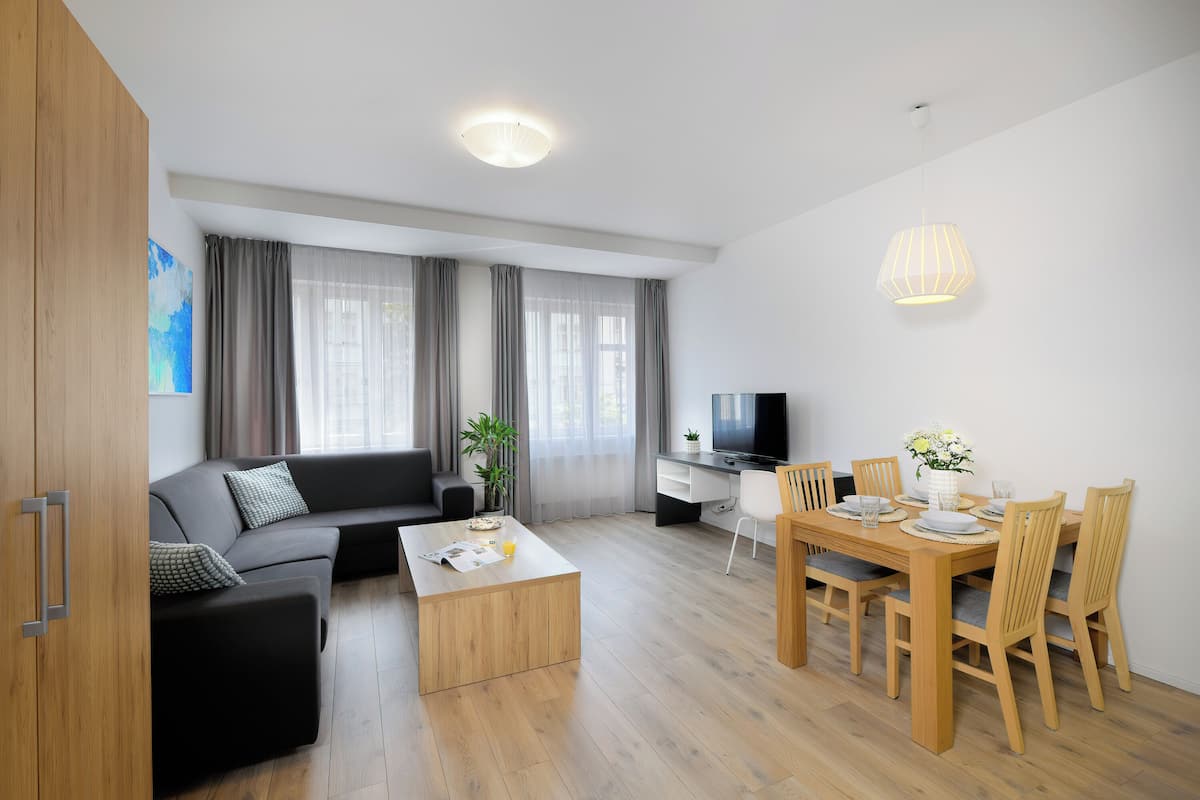 Een moderne woonkamer met een bank, salontafel, eettafel en stoelen.