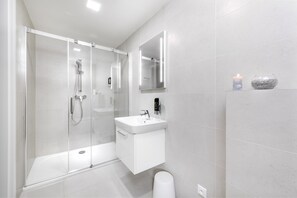 Estúdio executivo, 1 cama King, cozinha, vista para a cidade | Banheiro | Chuveiro, produtos de toalete grátis, secador de cabelo