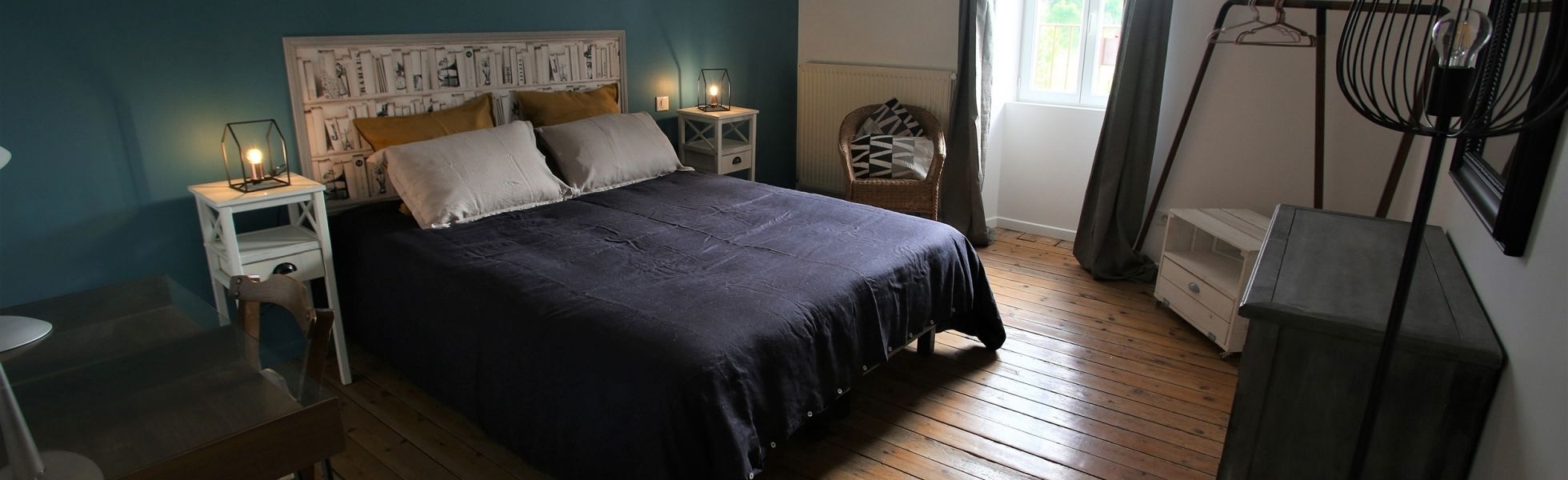Une chambre à coucher avec un grand lit, une table de chevet avec une lampe, une chaise et un radiateur.