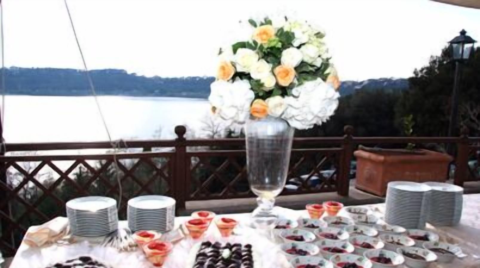 A table set for a meal with a floral centerpiece, plates, and various food items.