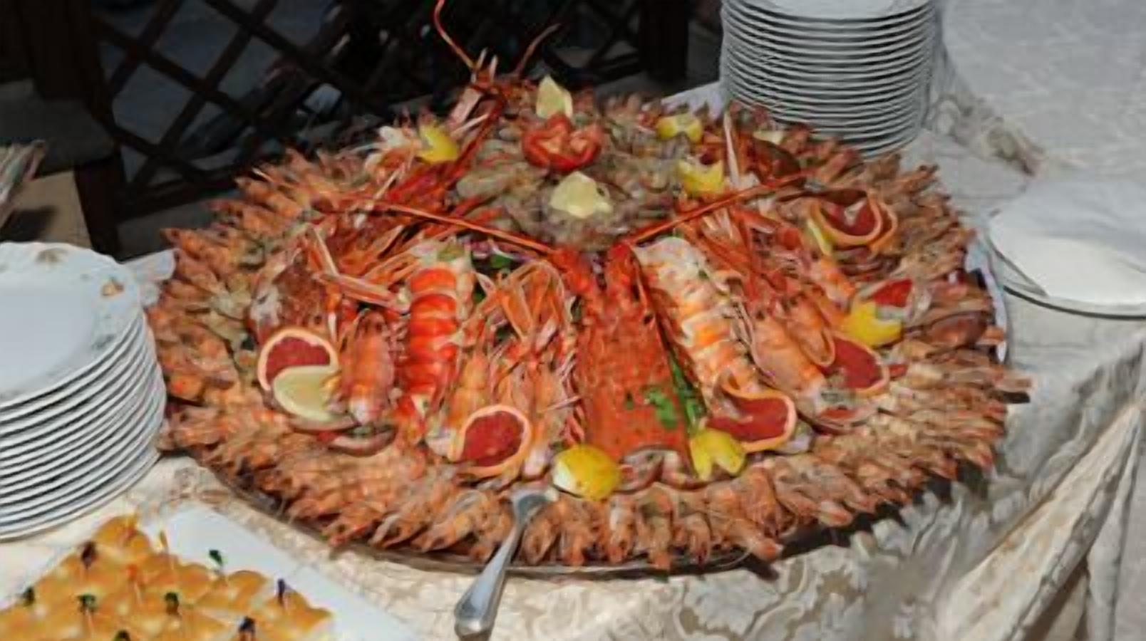 A seafood platter with various types of shellfish and garnishes, surrounded by stacked white plates.