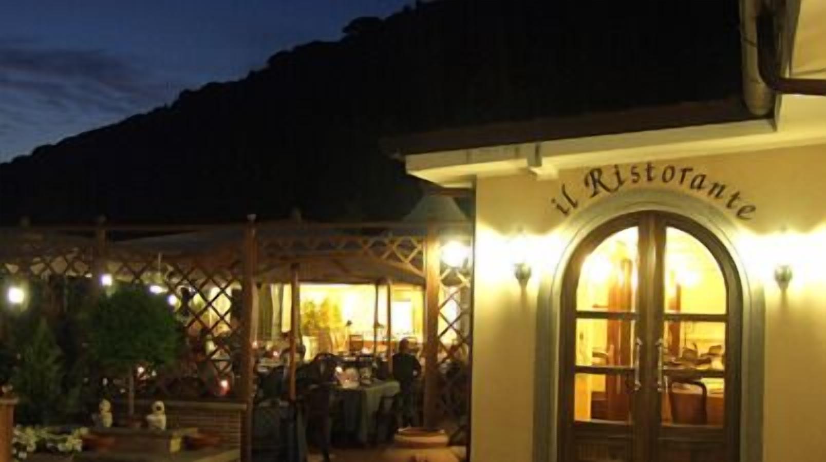 A restaurant with outdoor seating and a warm, inviting entrance.