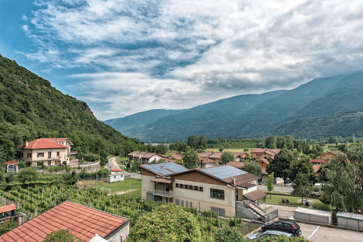 A residential area with houses, a parking lot, and a mountainous backdrop.