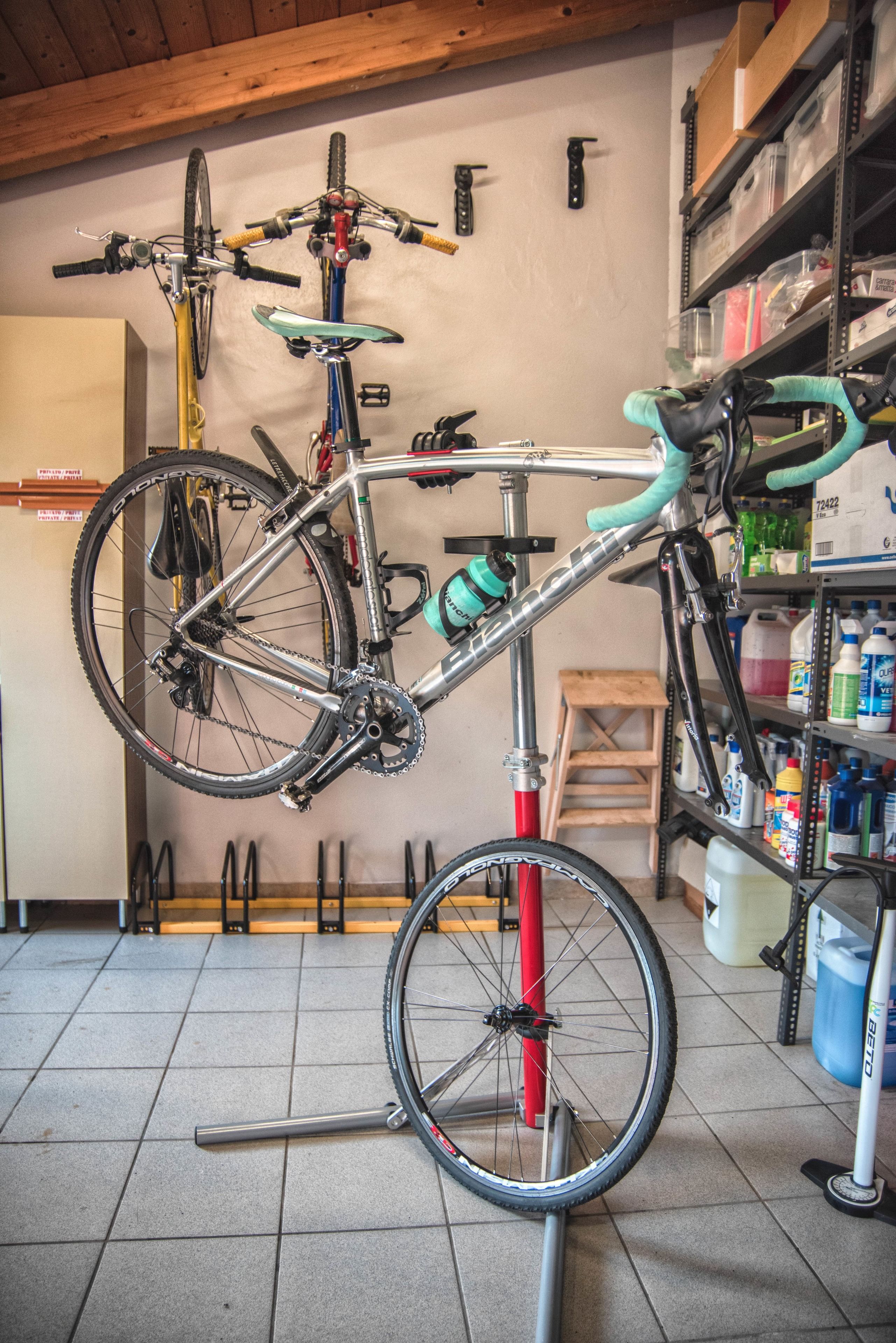 Una estación de reparación de bicicletas con herramientas y un estante de productos de limpieza.