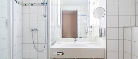 Un baño moderno con ducha, lavamanos y retrete.