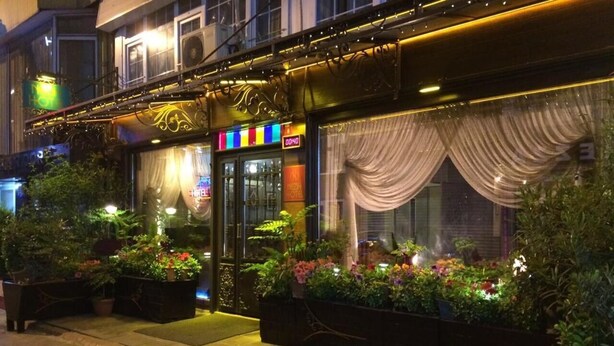 A hotel entrance with a glass door, outdoor plants, and decorative lighting. - Hotel Nezih Istanbul (Istanbul)