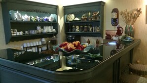 A kitchen with shelves holding various kitchenware and a central island with a vase of flowers. - Hotel Nezih Istanbul (Istanbul)