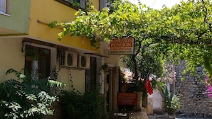 A building with multiple balconies, some with plants and a sign indicating a family atmosphere.