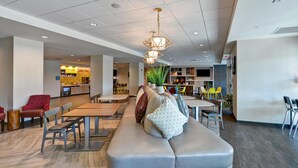 A modern interior with a seating area, a kitchen, and a dining space. - Home2 Suites by Hilton Tampa USF Near Busch Gardens (Tampa)
