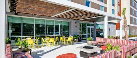 An outdoor seating area with yellow chairs and a covered patio.