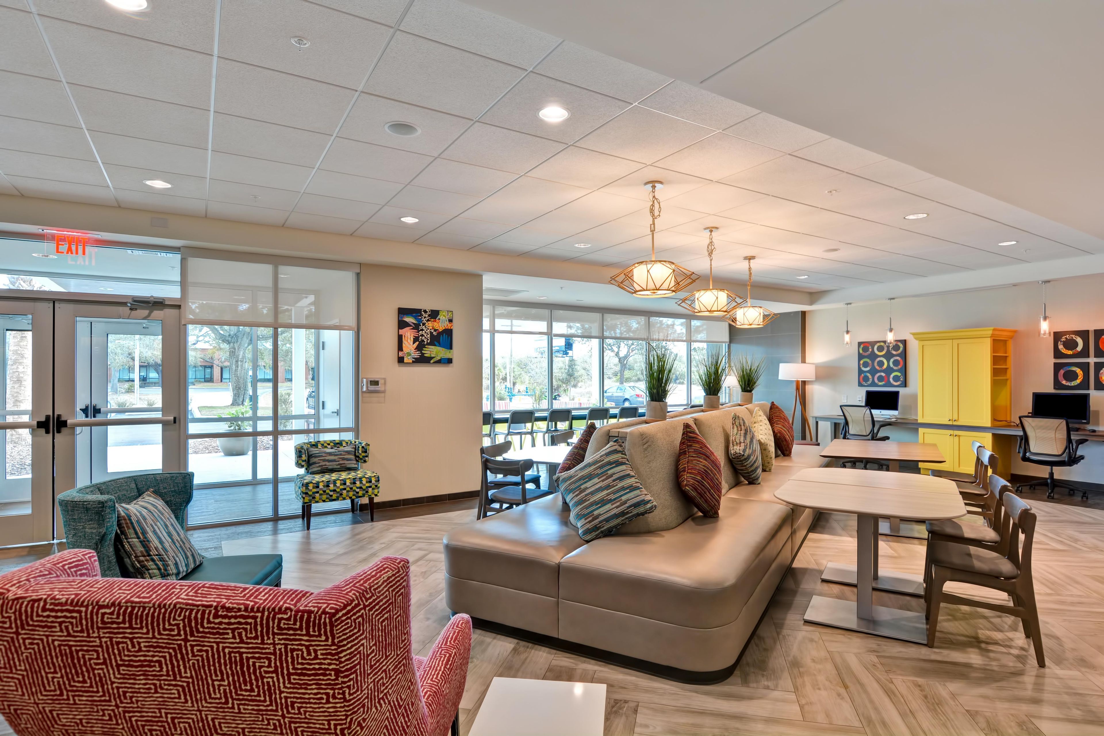 A spacious lobby with a seating area, a small table, and a computer desk.