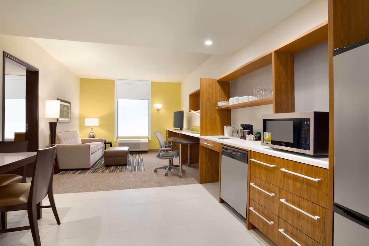 A modern kitchen with a microwave, dishwasher, and wooden cabinets.