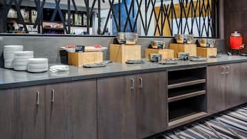 A buffet setup with various food items and utensils.