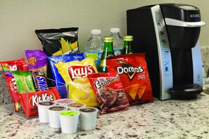 A variety of snacks and beverages on a kitchen counter.