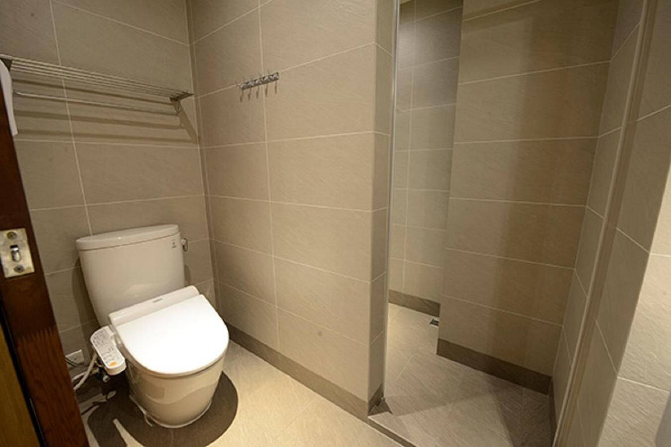 A small bathroom with a toilet, a shower, and a sink.