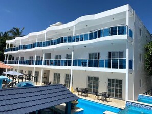A multi-story hotel with balconies, a swimming pool, and outdoor seating. - El Cabarete Spa & Resort (Cabarete)
