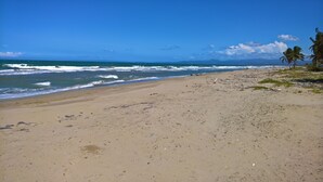 A beach with a clear view of the ocean and distant mountains.