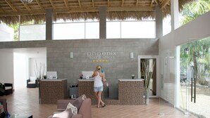 A reception area with a 'Phoenix spa & resort' sign, a reception desk, a waiting area with a sofa, and a glass door leading outside.