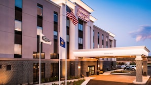 A Hampton Inn & Suites hotel with a clear entrance, American and Wisconsin state flags, and a 'Welcome' sign. - Hampton Inn & Suites at Wisconsin Dells Lake Delton (Baraboo)