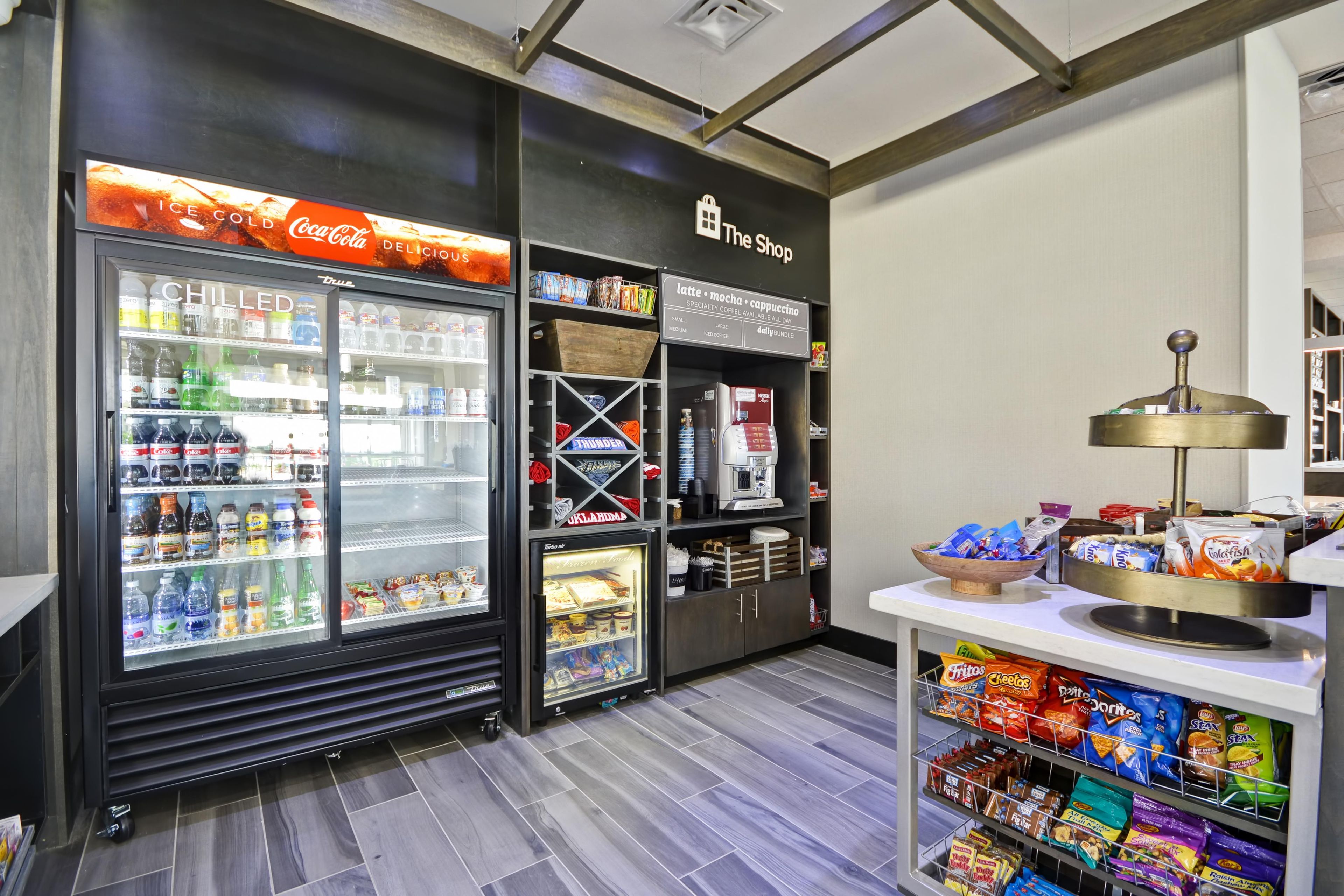 A vending area with various snacks and beverages, including a Coca-Cola cooler and a coffee machine.