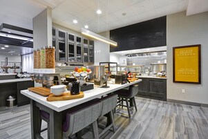 Una cocina moderna con una isla central, una cafetera y una presentación de frutas.