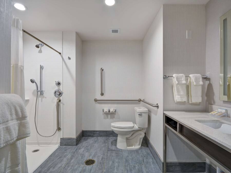 A modern bathroom with a shower, toilet, and vanity.