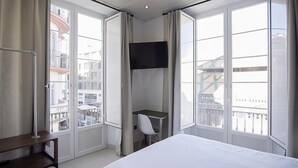 Ein Hotelzimmer mit Bett, Schreibtisch und Fernseher.