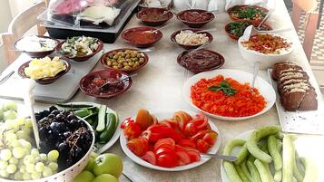 Una mesa de buffet con diversos alimentos, como frutas, verduras y salsas.