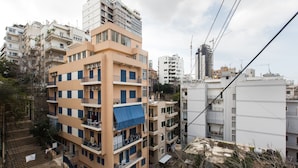 A multi-story residential building with balconies, a staircase, and a visible power line. - The Grand Meshmosh Hotel (Beirut)