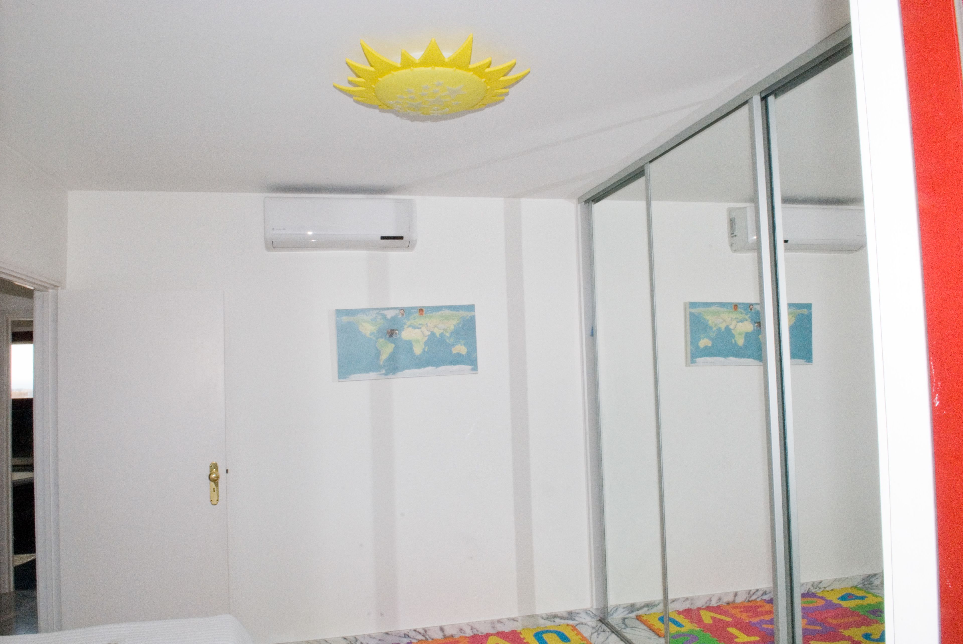 Ein Hotelzimmer mit weißer Wand, Deckenventilator, einer Karte und einem Fenster.