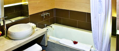 A modern bathroom with a large sink, a bathtub, and a wooden vanity.