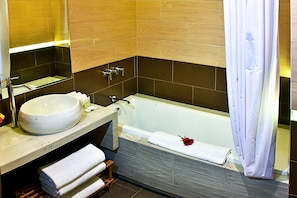 Bathroom features a bathtub, sink, and wooden cabinetry.