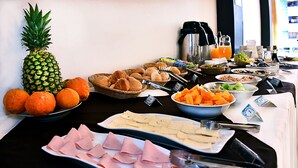Een buffet met diverse gerechten, waaronder fruit, gebak en vlees.