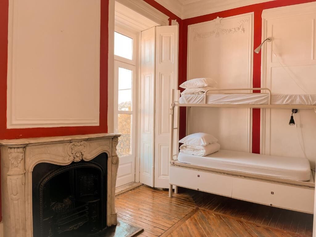 Una habitación con chimenea, una litera y una puerta que da a un balcón.