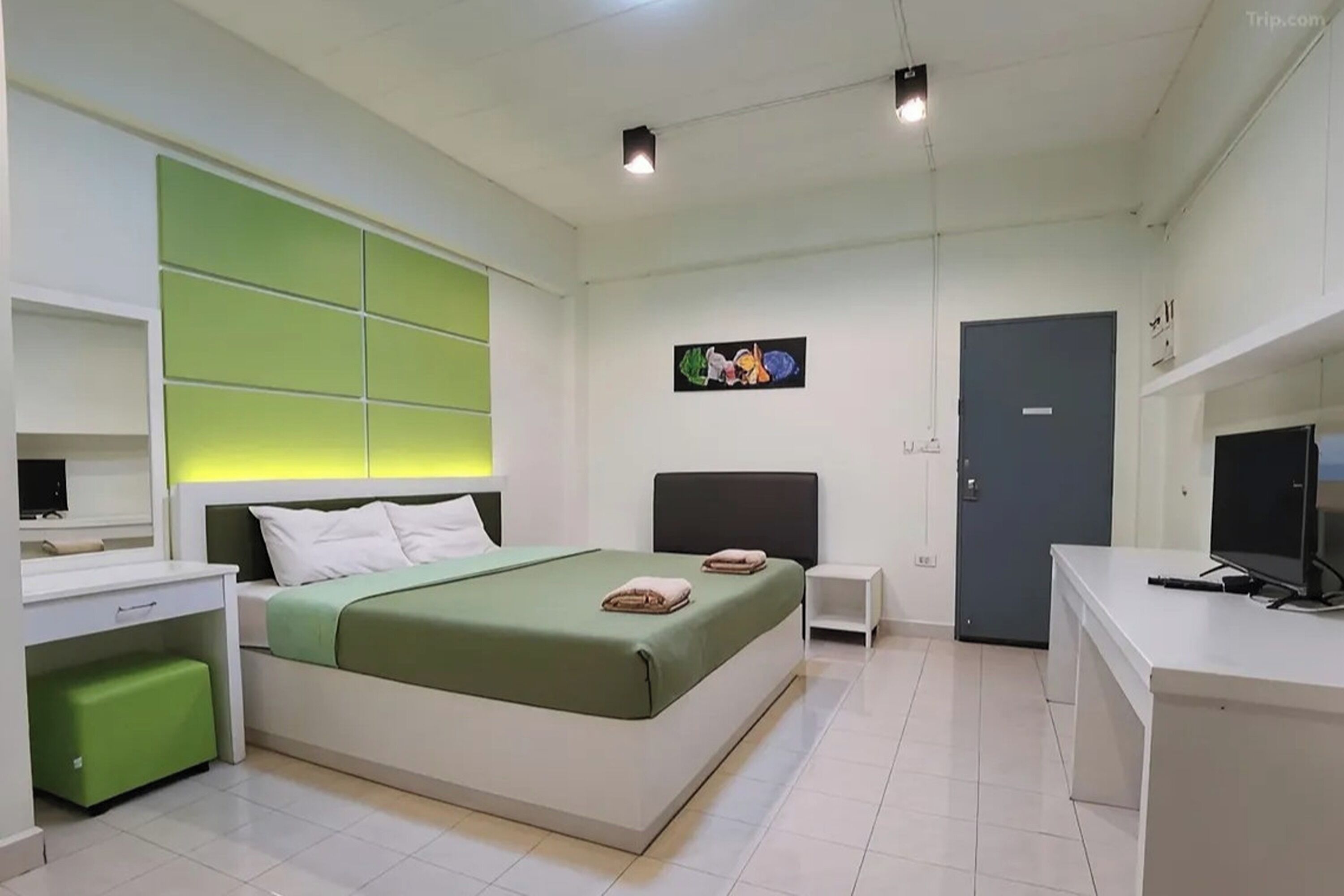 Ein modernes Schlafzimmer mit Bett, Nachttischen, einem Schreibtisch und einer Tür.