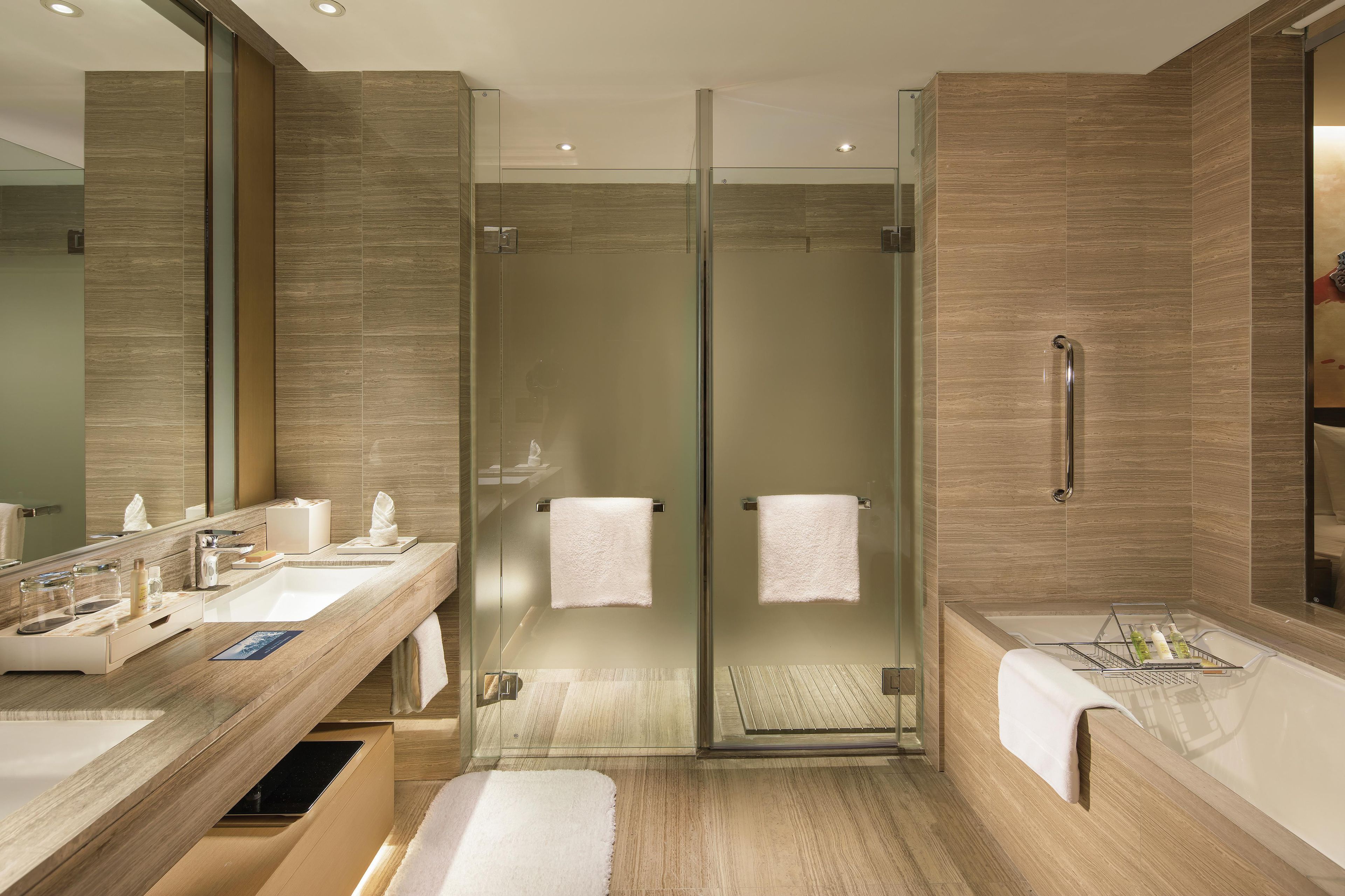 A modern bathroom with a glass-enclosed shower, dual sinks, and a large mirror.