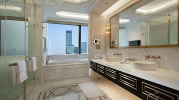 Une salle de bain moderne avec un grand miroir, deux vasques et une baignoire.
