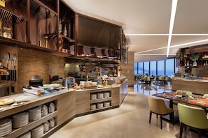Un intérieur de restaurant moderne avec un comptoir central, un espace repas et une cuisine.