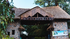 Un edificio rústico de piedra con tejado de paja y un letrero que dice "RIFFUTI RESORT & SPA".
