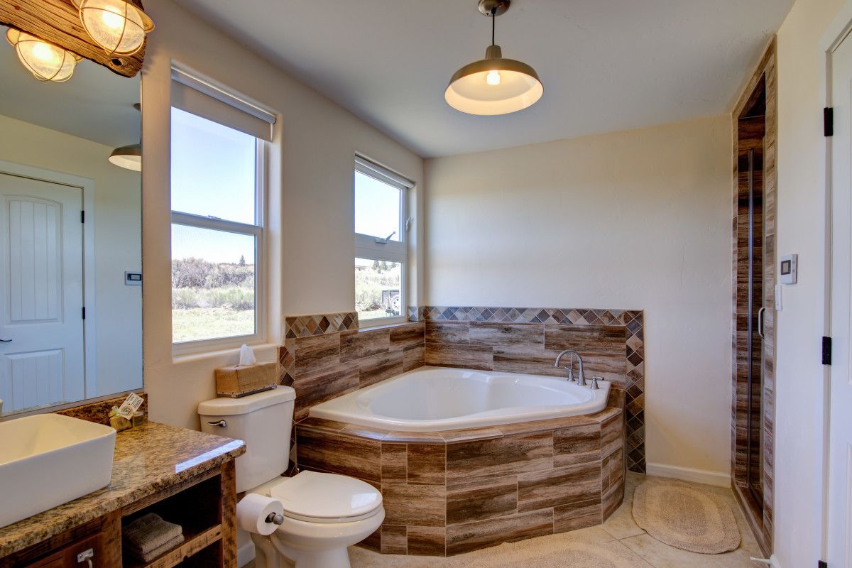 A bathroom with a large bathtub, a toilet, and a sink.