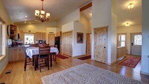 A spacious kitchen with wooden cabinets, a dining area with a table and chairs, and a large rug on the floor. - Ridgetop Hideaway (Hatch)
