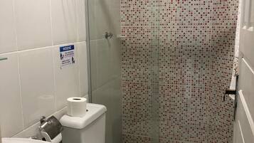 A bathroom with a toilet, sink, and shower.