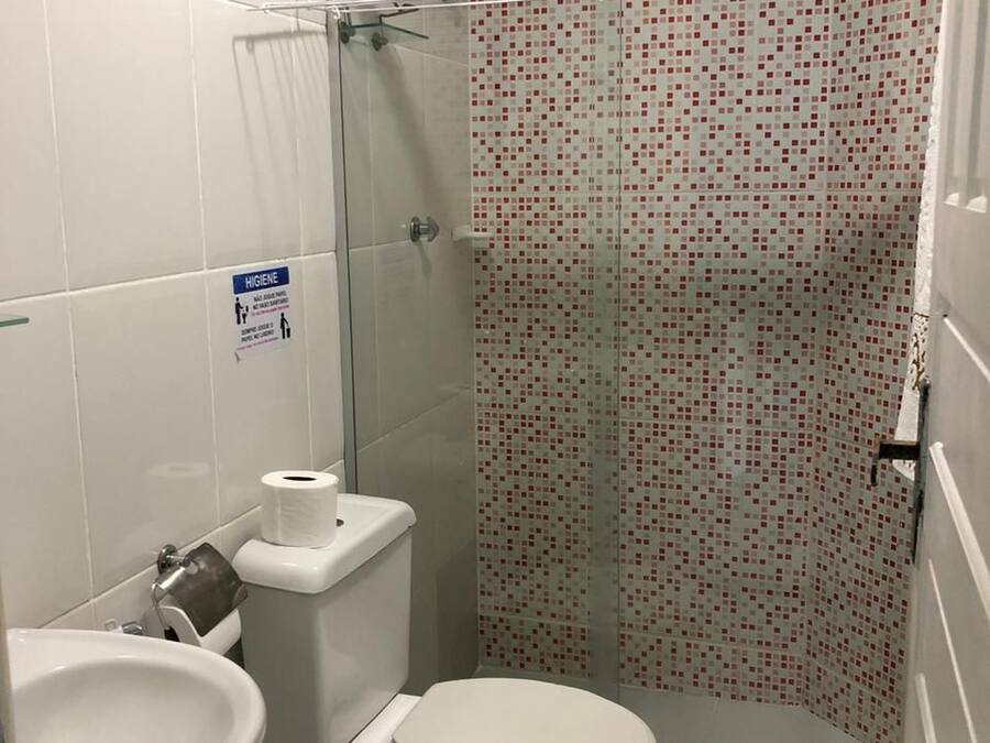 A bathroom with a toilet, sink, and shower.